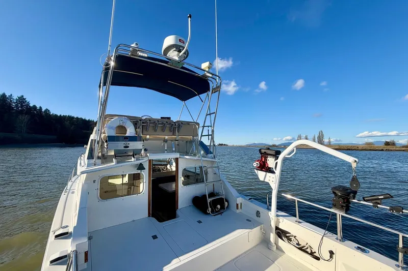 Slide: The Image of 1981 Bertram 28 Flybridge Cruiser on calm water under clear blue sky. - 10
