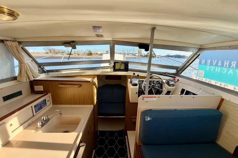 Slide: The Image of Interior of a 1981 Bertram 28 Flybridge Cruiser with helm, seating, and kitchenette. - 14