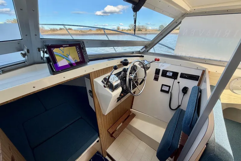 Slide: The Image of 1981 Bertram 28 Flybridge Cruiser helm with navigation equipment and steering wheel. - 20