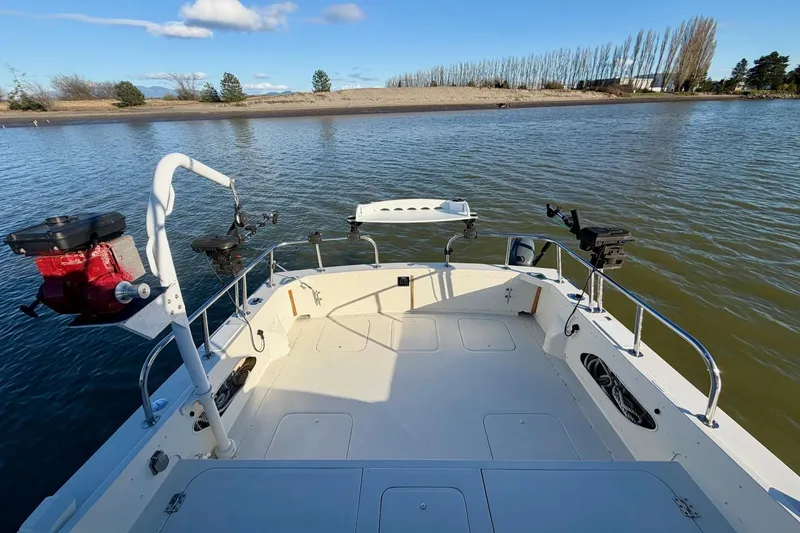 Slide: The Image of 1981 Bertram 28 Flybridge Cruiser on calm water, featuring fishing equipment and clear skies. - 9
