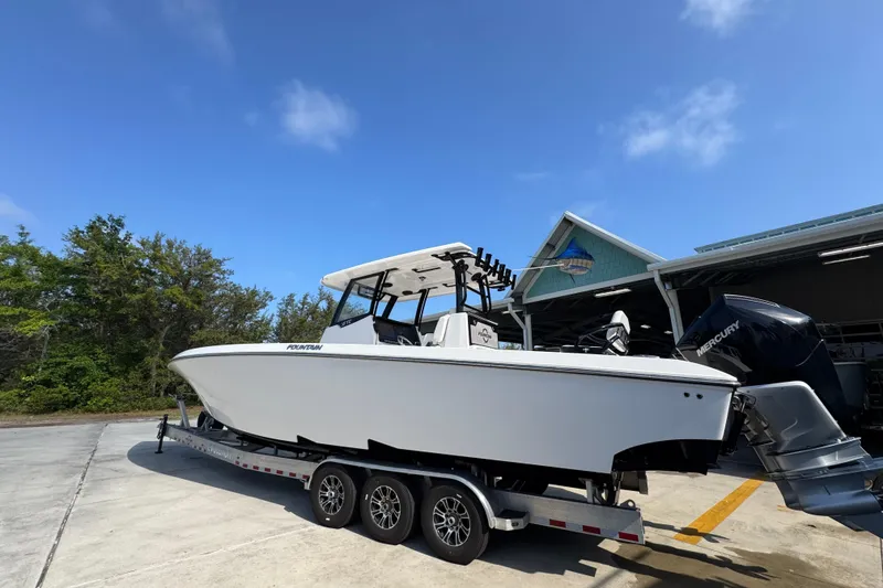 Slide: The Image of 2024 Fountain Bluewater 38 Tournament Edition boat on trailer, clear sky background. - 13
