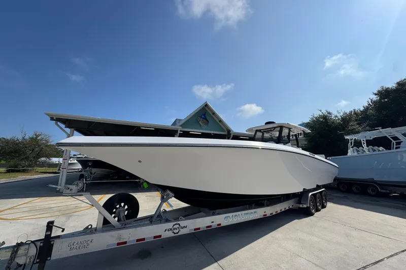 Slide: The Image of 2024 Fountain Bluewater 38 Tournament Edition boat on trailer under clear sky. - 3
