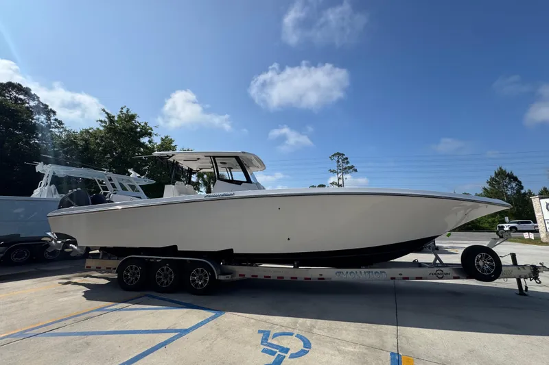 Slide: The Image of 2024 Fountain Bluewater 38 Tournament Edition boat on trailer under clear sky. - 7