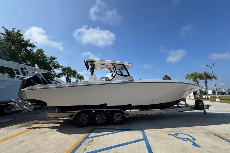 Slide: The Image of 2024 Fountain Bluewater 38 Tournament Edition boat on trailer under clear blue sky. - 8