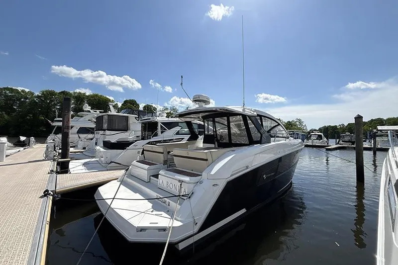 The Image of 2016 Cruisers Yachts 390 Express Coupe docked at marina under clear blue sky. - 0