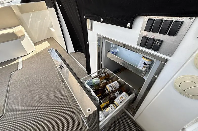 Slide: The Image of 2016 Cruisers Yachts 390 Express Coupe interior with open fridge stocked with beverages. - 11