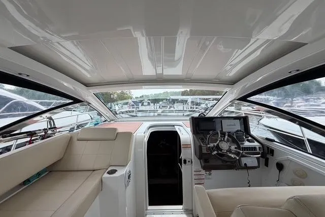 Slide: The Image of Interior view of 2016 Cruisers Yachts 390 Express Coupe, featuring helm and seating area. - 12