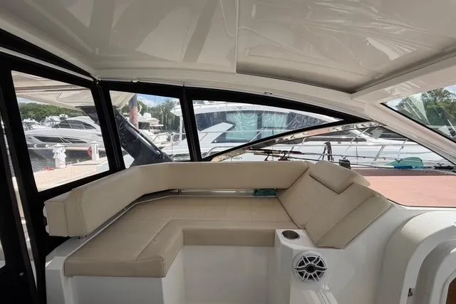 Slide: The Image of Interior of 2016 Cruisers Yachts 390 Express Coupe with beige seating and large windows. - 14
