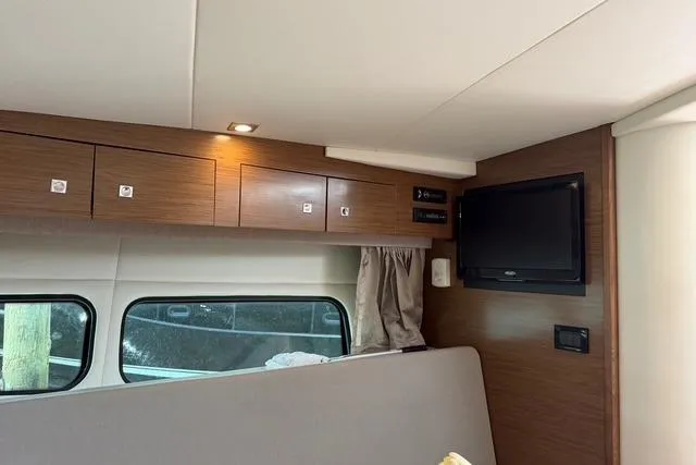 Slide: The Image of Interior of 2016 Cruisers Yachts 390 Express Coupe with wood cabinets and mounted TV. - 19