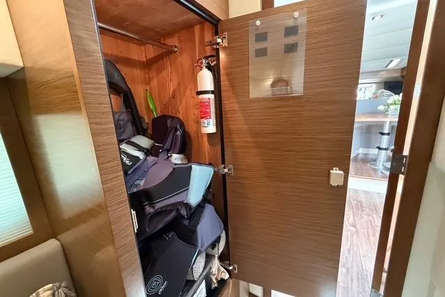 Slide: The Image of Storage closet inside 2016 Cruisers Yachts 390 Express Coupe, featuring life jackets and a fire extinguisher. - 26