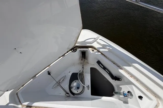 Slide: The Image of 2016 Cruisers Yachts 390 Express Coupe anchor compartment with open hatch, docked on water. - 28