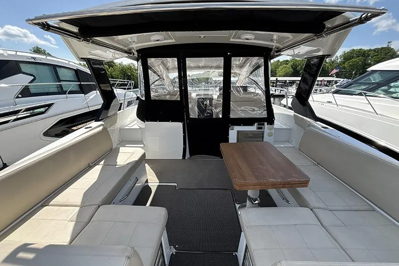 Slide: The Image of 2016 Cruisers Yachts 390 Express Coupe interior with seating and table, docked at marina. - 3