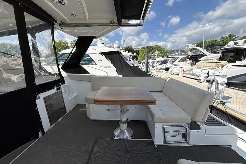 Slide: The Image of 2016 Cruisers Yachts 390 Express Coupe interior with seating and table at marina. - 5