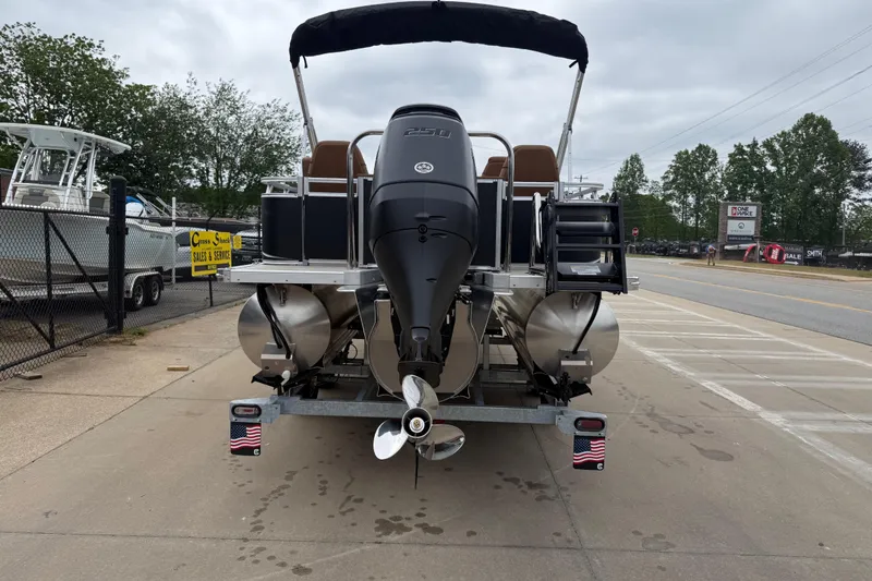 Slide: The Image of 2026 Avalon LSZ Rear Fish boat on trailer, rear view with motor and American flag decals. - 4