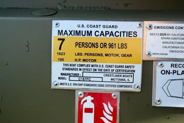 Slide: The Image of U.S. Coast Guard capacity label on 2026 Crestliner 1870 Retriever FCC boat, showing maximum limits. - 12