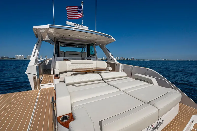 Slide: The Image of 2024 Tiara Yachts 48 LS luxury yacht with spacious deck and seating, cruising on open water. - 17
