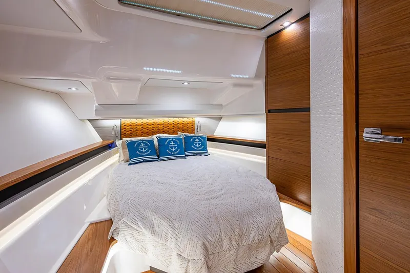 Slide: The Image of Luxurious cabin interior of 2024 Tiara Yachts 48 LS with cozy bedding and elegant wood finishes. - 32