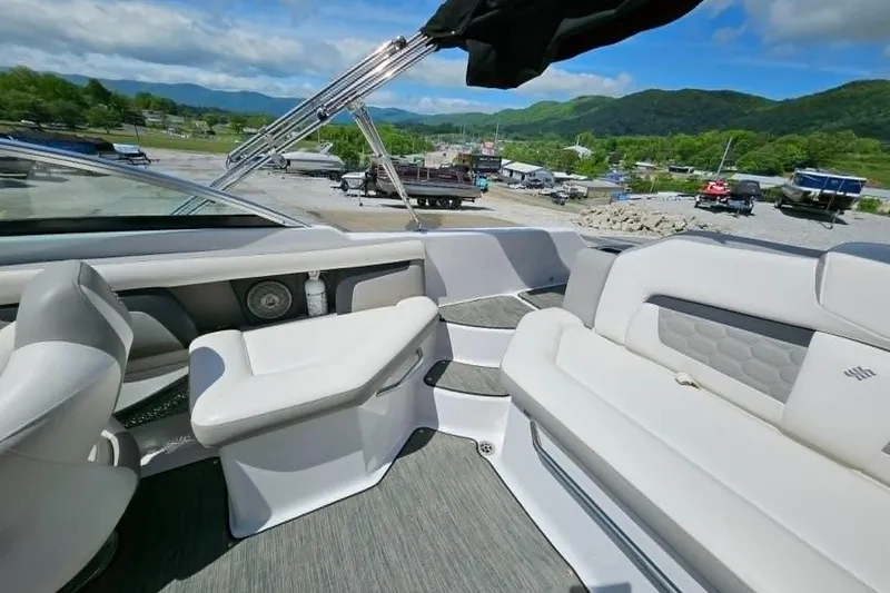 Slide: The Image of 2019 Four Winns HD220 boat interior with plush seating and scenic mountain backdrop. - 21