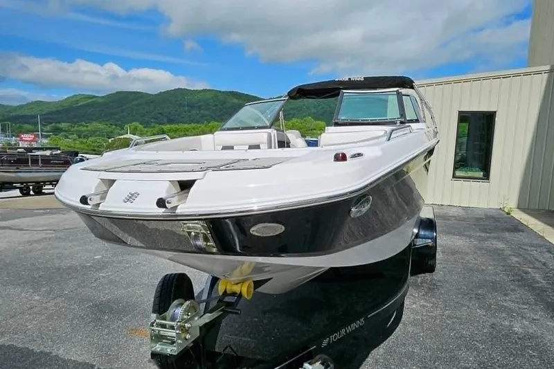 Slide: The Image of 2019 Four Winns HD220 boat on trailer, parked outdoors with scenic mountain backdrop. - 3