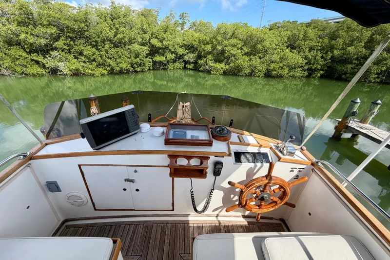 Slide: The Image of Cockpit of 1983 Grand Banks 32 Sedan with wooden steering wheel and navigation equipment. - 13