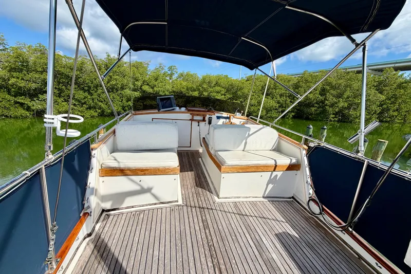 Slide: The Image of 1983 Grand Banks 32 Sedan boat interior with seating, wooden deck, and canopy. - 19