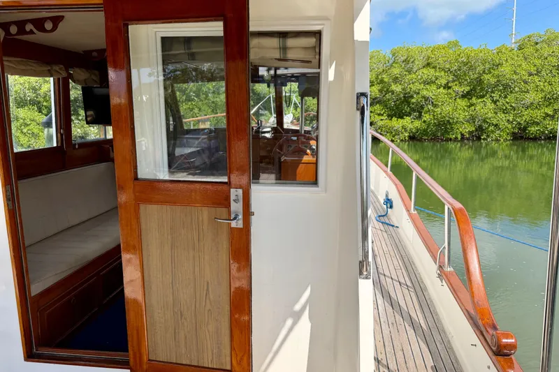 Slide: The Image of 1983 Grand Banks 32 Sedan boat interior with wooden door and scenic water view. - 20