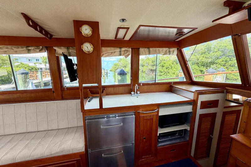 Slide: The Image of Interior of a 1983 Grand Banks 32 Sedan with wood cabinetry and scenic window views. - 28