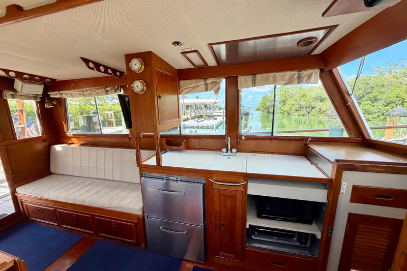 Slide: The Image of Interior of 1983 Grand Banks 32 Sedan with wood finish, seating, and kitchen appliances. - 30