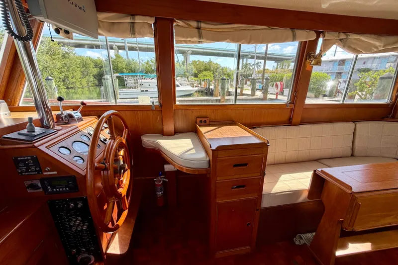 Slide: The Image of Interior of 1983 Grand Banks 32 Sedan with wooden helm and seating area. - 34