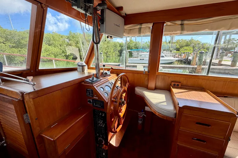Slide: The Image of 1983 Grand Banks 32 Sedan helm with wooden interior and marina view. - 35