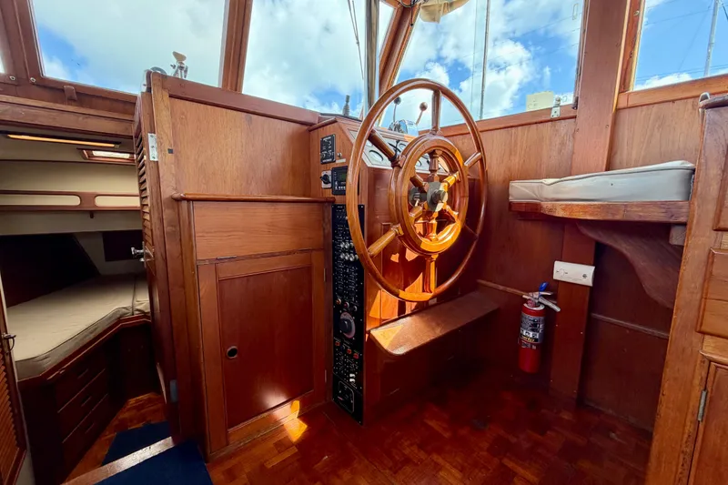 Slide: The Image of 1983 Grand Banks 32 Sedan interior with wooden helm and cabin view. - 36
