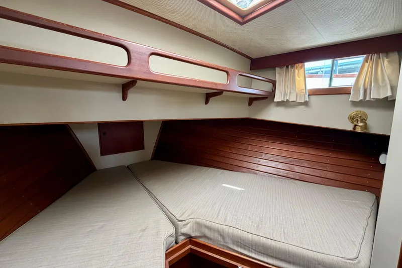 Slide: The Image of Cozy cabin interior of 1983 Grand Banks 32 Sedan with wooden accents and bedding. - 39