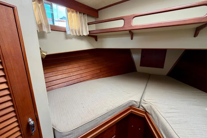 Slide: The Image of Cozy cabin interior of 1983 Grand Banks 32 Sedan with wooden accents and cushioned berth. - 40