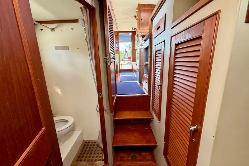 Slide: The Image of Interior of 1983 Grand Banks 32 Sedan, featuring wooden cabinetry and compact bathroom. - 42