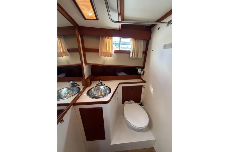 Slide: The Image of 1983 Grand Banks 32 Sedan bathroom with sink, toilet, and mirror. - 45