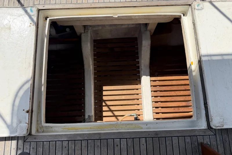 Slide: The Image of Open hatch on 1983 Grand Banks 32 Sedan boat deck, revealing wooden slats inside. - 49