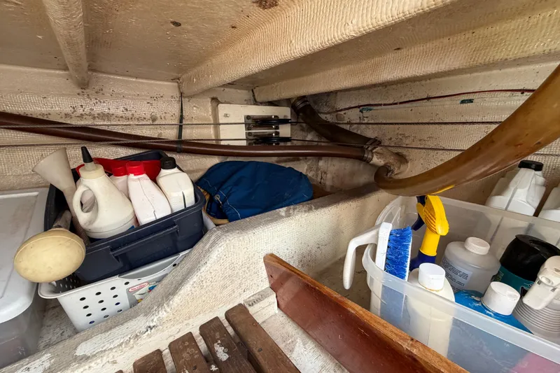Slide: The Image of Storage area on a 1983 Grand Banks 32 Sedan with cleaning supplies and containers. - 55