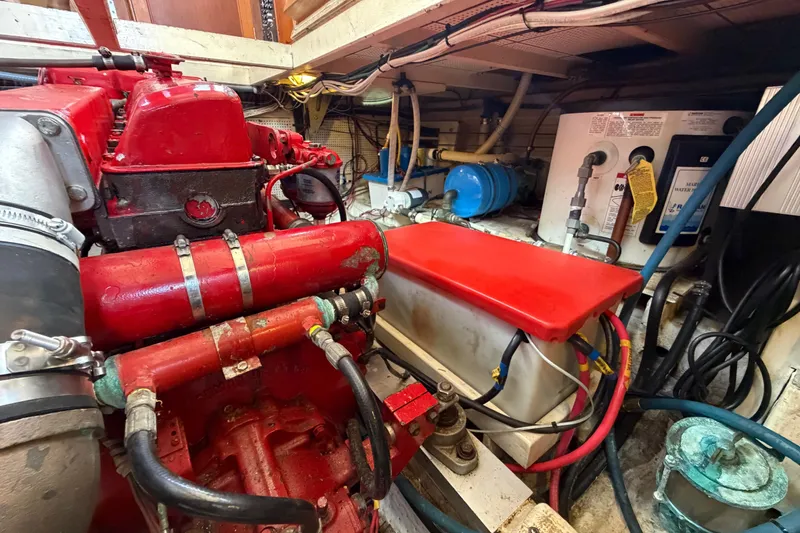 Slide: The Image of Engine room of a 1983 Grand Banks 32 Sedan with red machinery and wiring. - 58