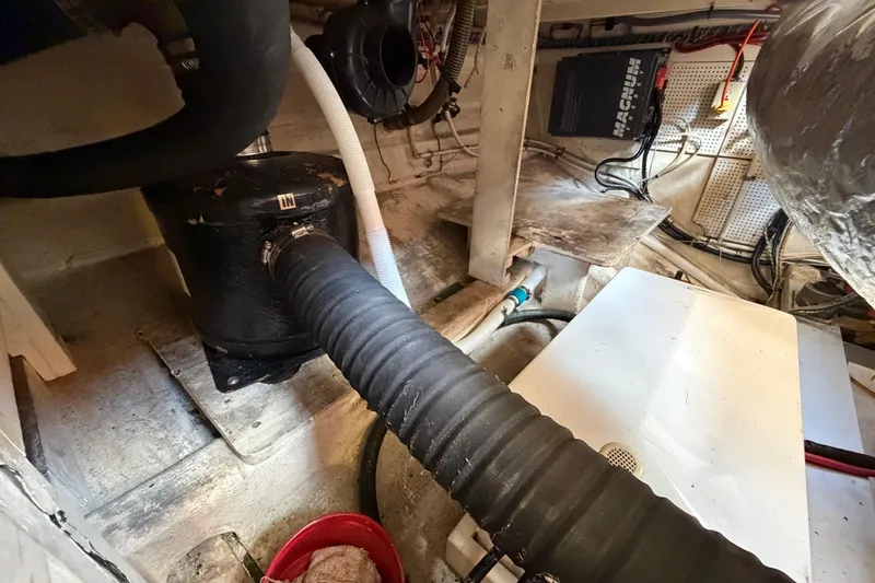 Slide: The Image of Engine room of a 1983 Grand Banks 32 Sedan with visible hoses and equipment. - 60