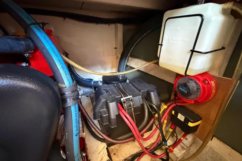 Slide: The Image of Engine compartment of 1983 Grand Banks 32 Sedan with wiring and fluid container. - 63