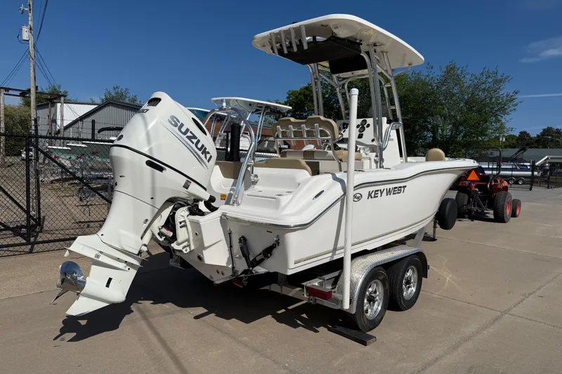 Slide: The Image of 2017 Key West 219 FS boat with Suzuki engine on trailer, parked outdoors. - 15