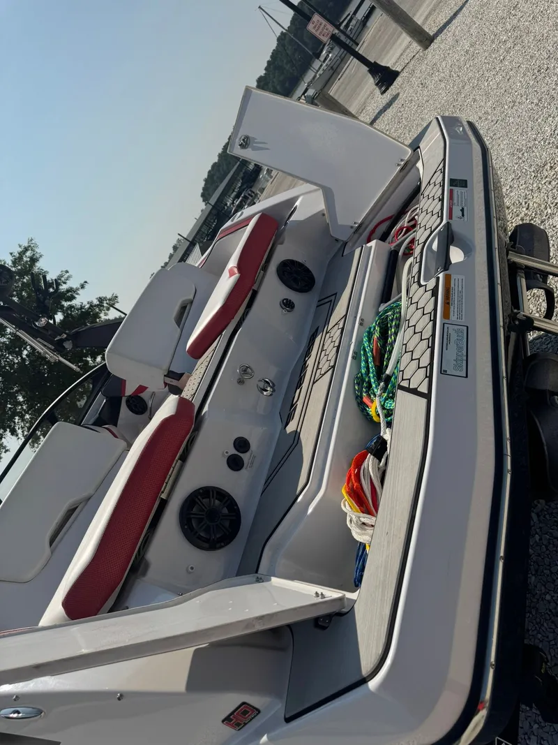 Slide: The Image of 2018 Scarab 215 ID boat with red seating at dock. - 15