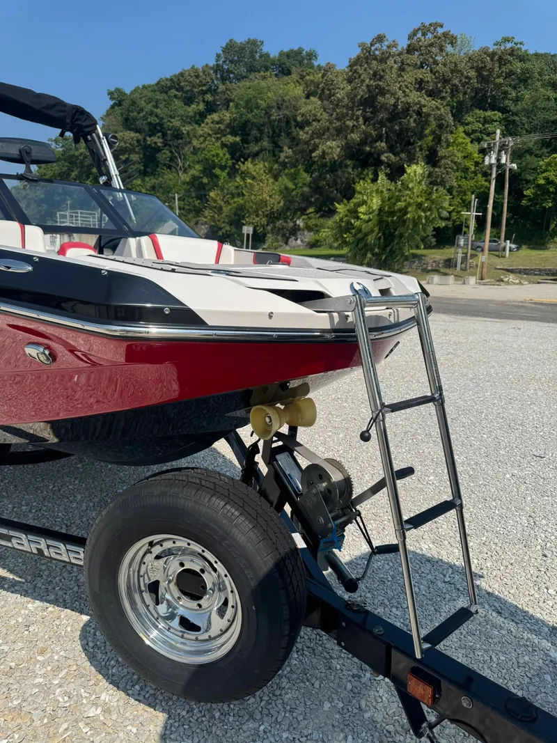 Slide: The Image of 2018 Scarab 215 ID boat on trailer with ladder. - 2