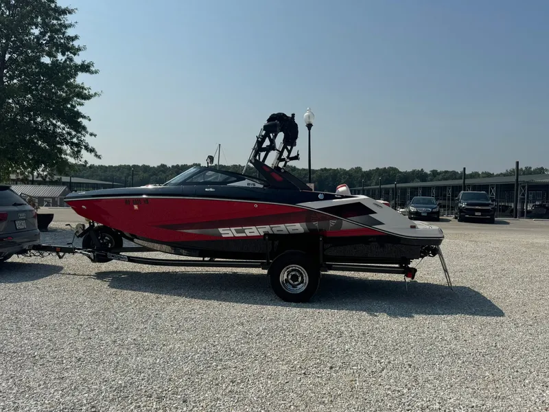 Slide: The Image of 2018 Scarab 215 ID boat parked on trailer outdoors. - 3