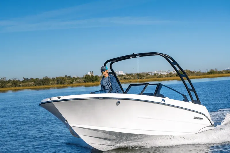 Slide: The Image of 2026 Stingray 20 SBX boat cruising on calm water. - 11