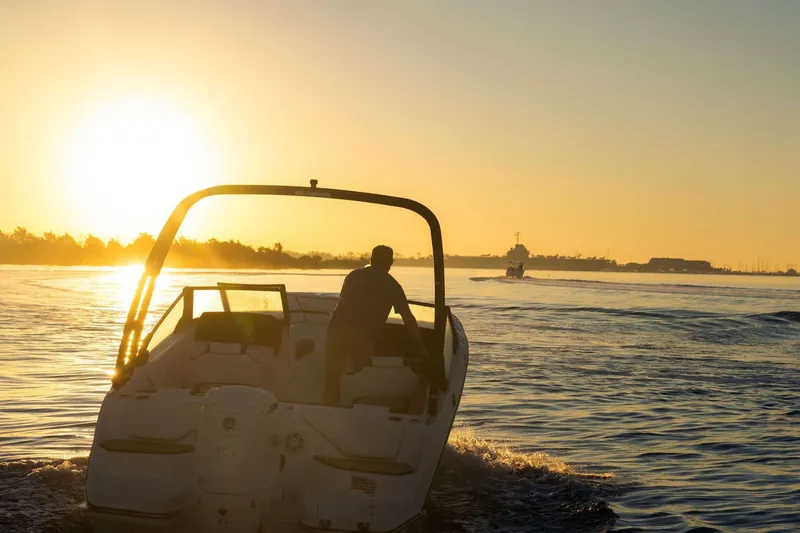Slide: The Image of Stingray 20 SBX 2026 boat cruising at sunset on the water. - 12