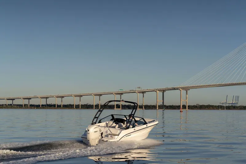 Slide: The Image of 2026 Stingray 20 SBX boat on calm water near bridge. - 15