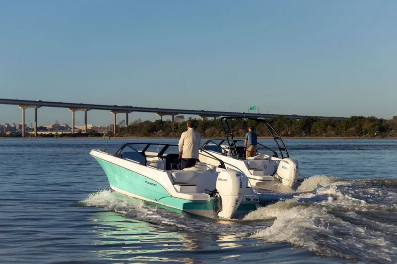 Slide: The Image of Two 2026 Stingray 20 SBX boats on a river near a bridge. - 16