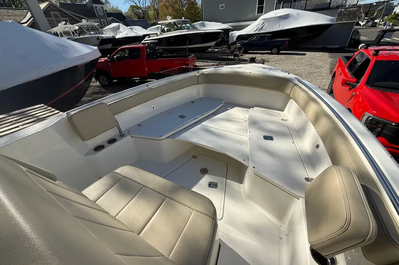 Slide: The Image of 2021 Pursuit S 268 Sport boat interior with beige seating, parked near red truck. - 12