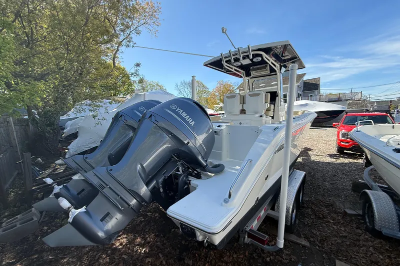 Slide: The Image of 2021 Pursuit S 268 Sport boat with Yamaha engines on a trailer, parked outdoors. - 2